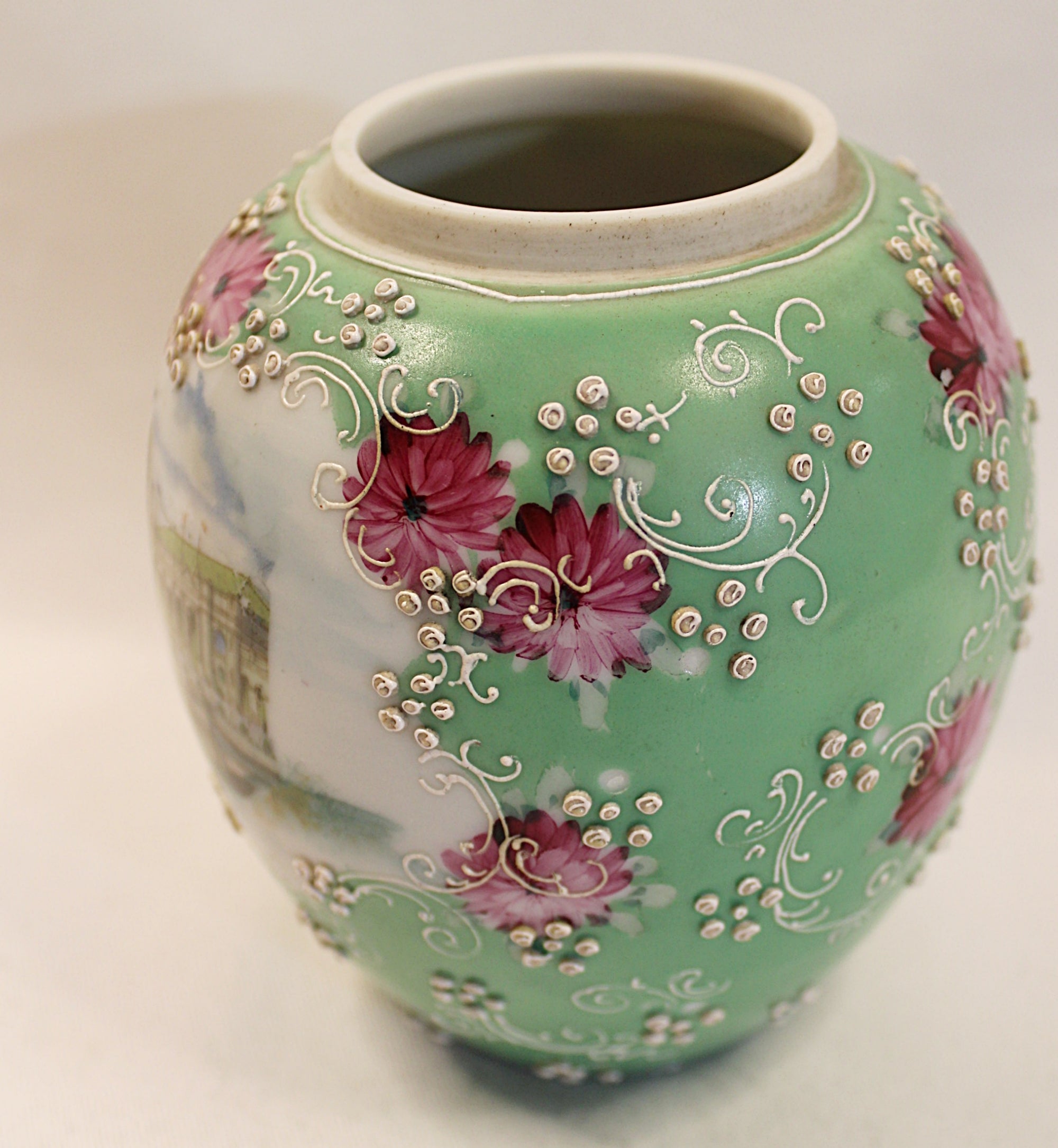 Decorative ceramic vase with floral patterns on a plain background