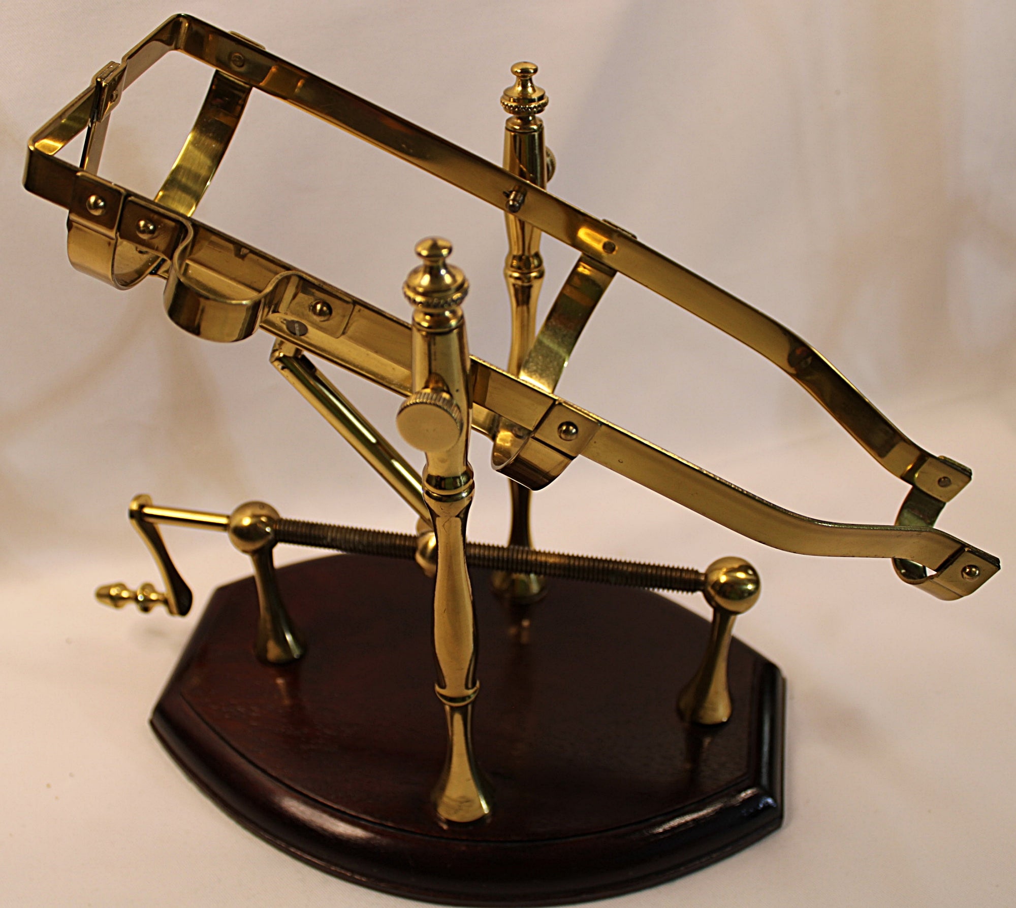 Brass Bottle holder on a wooden base against a white background