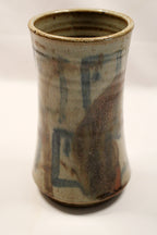Cylindrical ceramic vase with textured surface and blue accents on a white background by Bill Heyduck