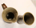 Two ceramic mugs with textured interior surfaces on a white background showing rim view of both. By Bill Heyduck potter.