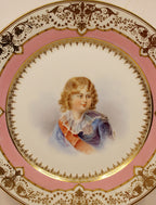 Decorative plate with a portrait of a child on a pink background center closeup