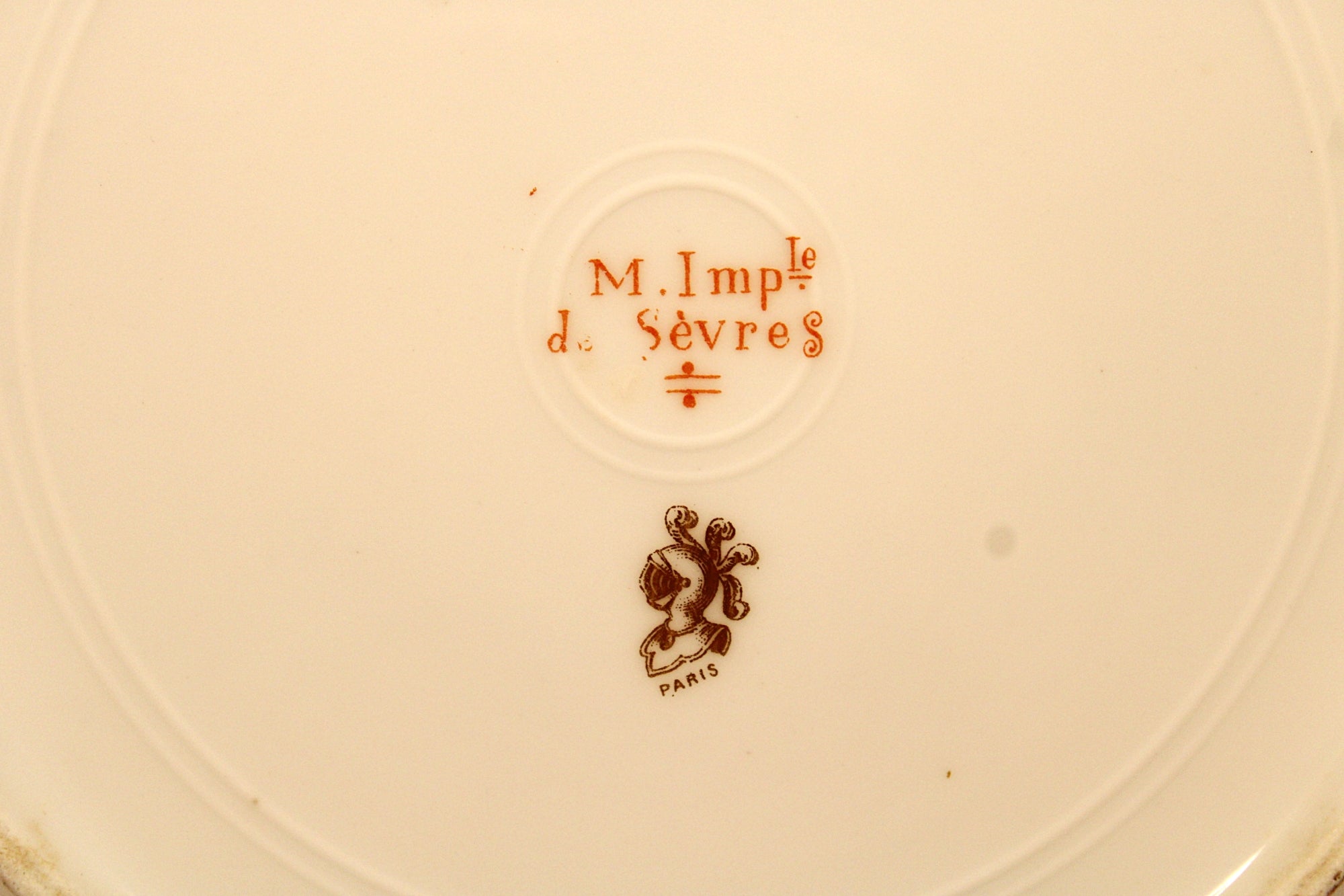 M. Imp Le d Sevres logo on a beige background
