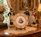 Decorative plate with a portrait on a table with figurines and books in an elegant room. Young Napolian