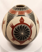A hand-painted Southwestern-style ceramic vase with a rounded body, featuring a prominent red turtle design with a black wheel motif on an off-white textured background, with red, black, and white geometric patterns on the neck and sides.