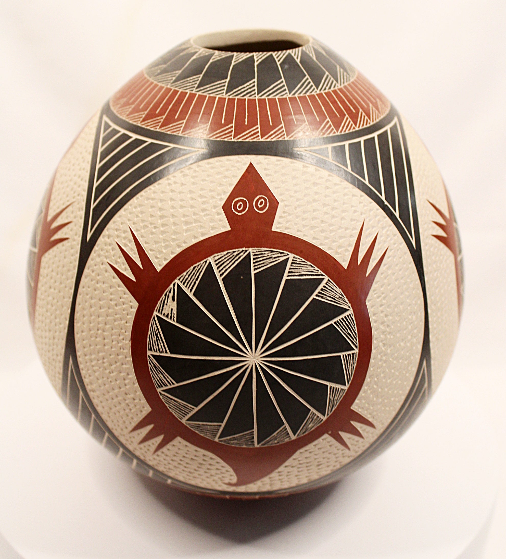 A hand-painted ceramic pot with a textured cream base, decorated with geometric patterns in black, red, and white.