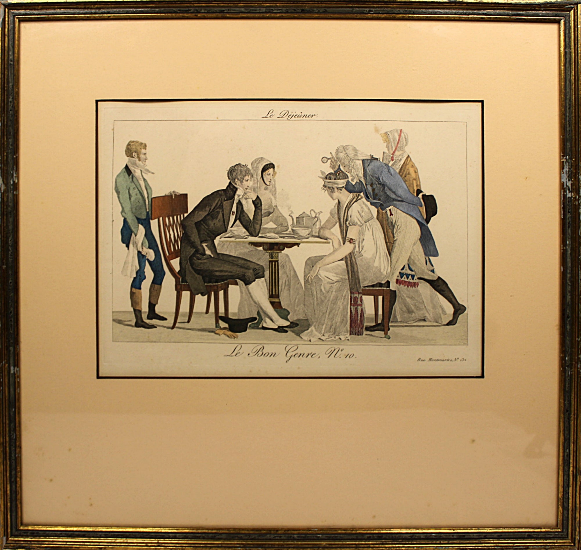 Framed artwork depicting a scene with people around a table, likely from a historical or classical context.