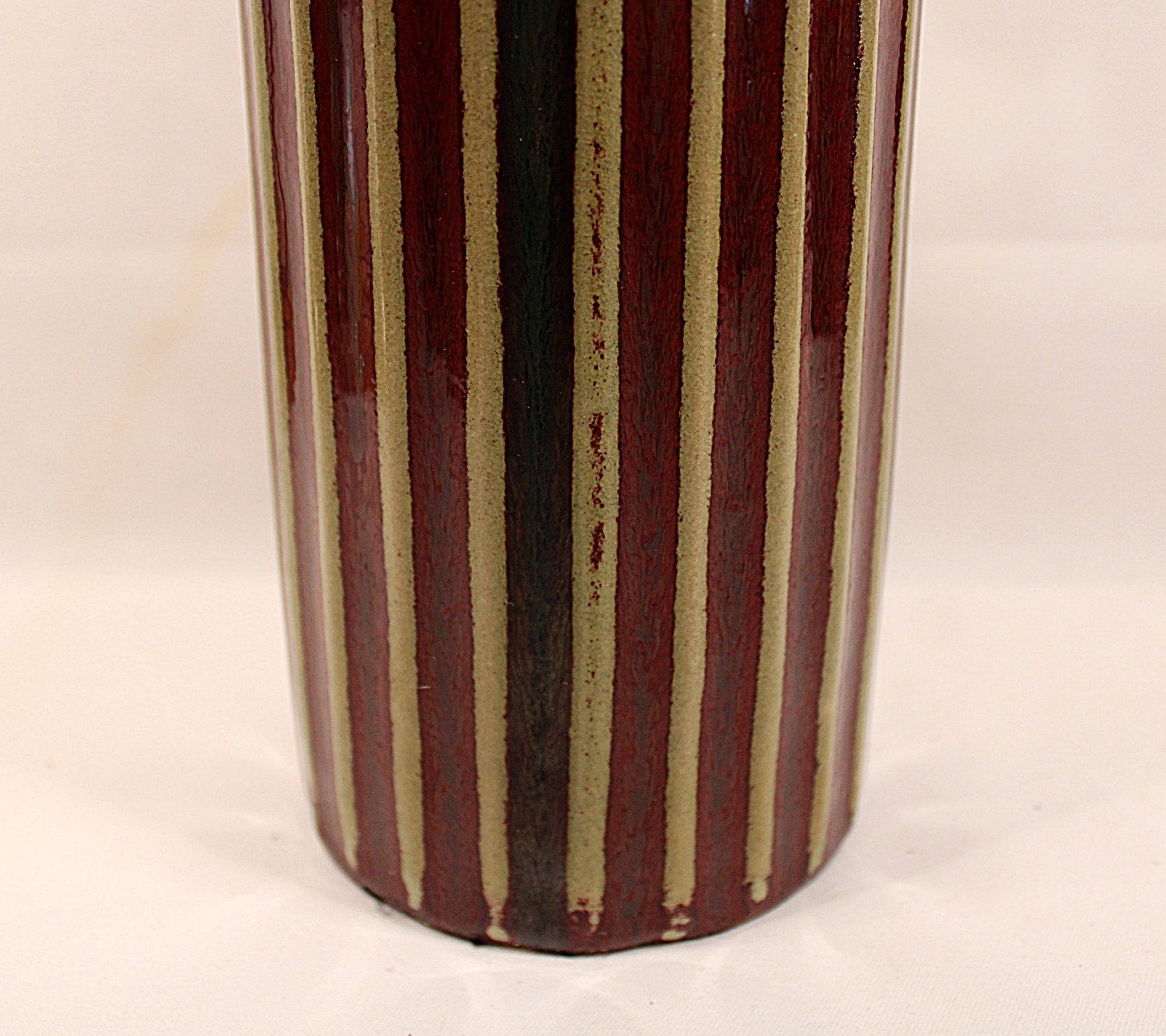 Bottom Half View Cylindrical ceramic vase with vertical striped pattern on a plain background