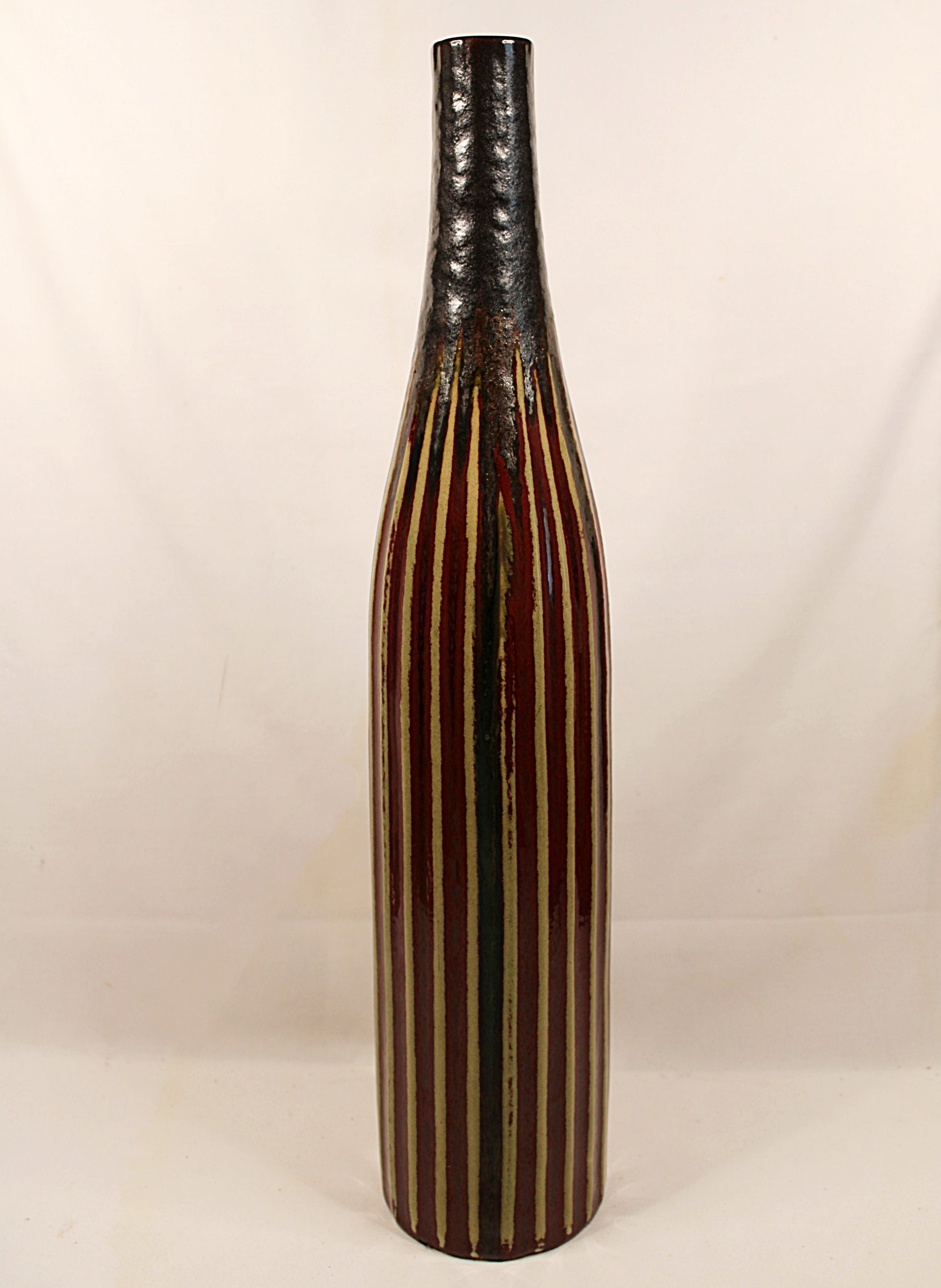 Tall ceramic vase with black and brown striped design on a white background