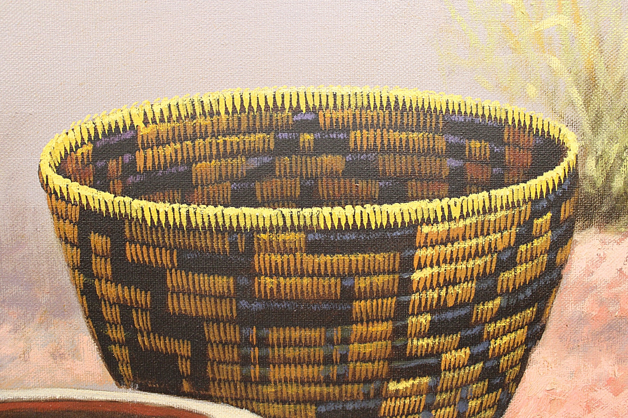 A close-up of a woven basket with a geometric pattern in blue, yellow, and brown, shown against a soft, painterly background.