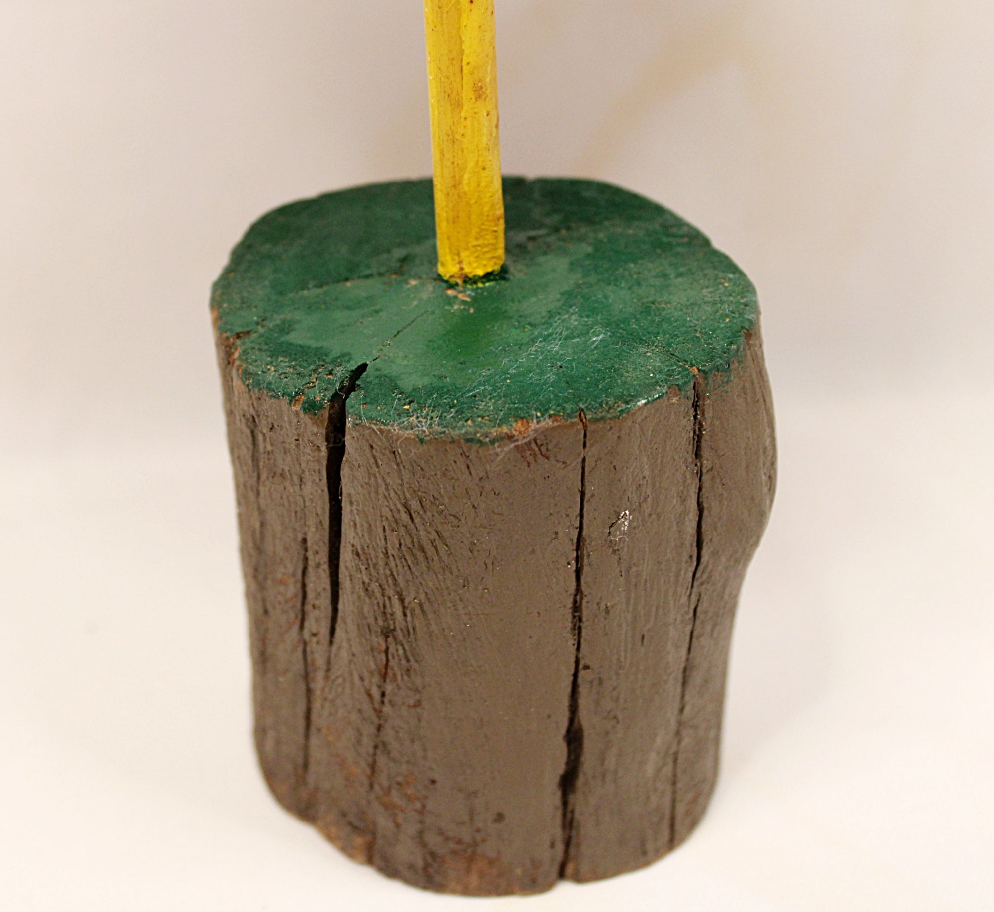 Wooden post with green top and yellow pole on a white background