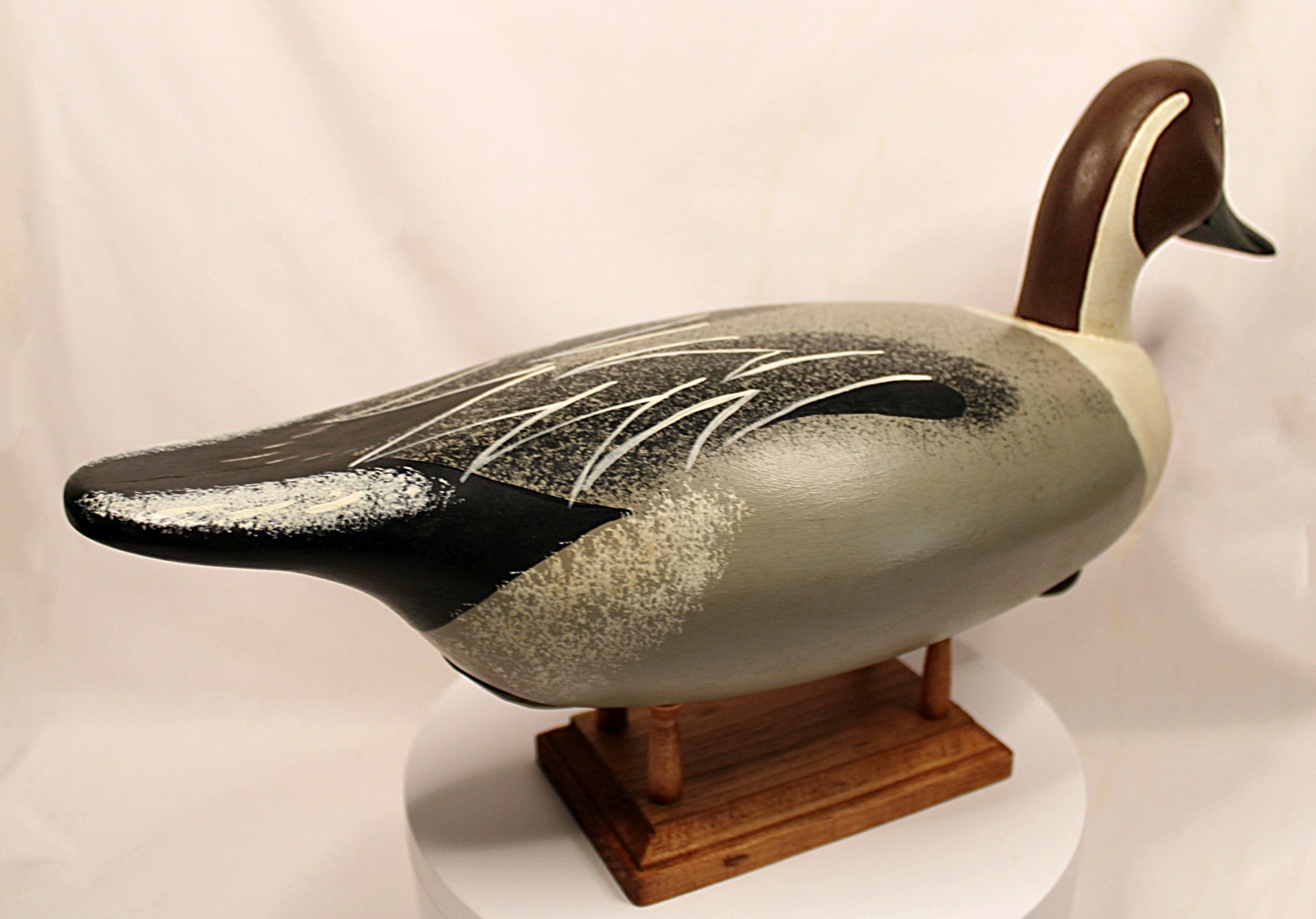 Decorative duck figure on a stand against a plain backgroung, Pintail Drake Duck Decoy Jim Burtis Maryland 1994
