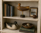 Wooden bird sculpture signeon a shelf with books and decorative items signed seth-93 